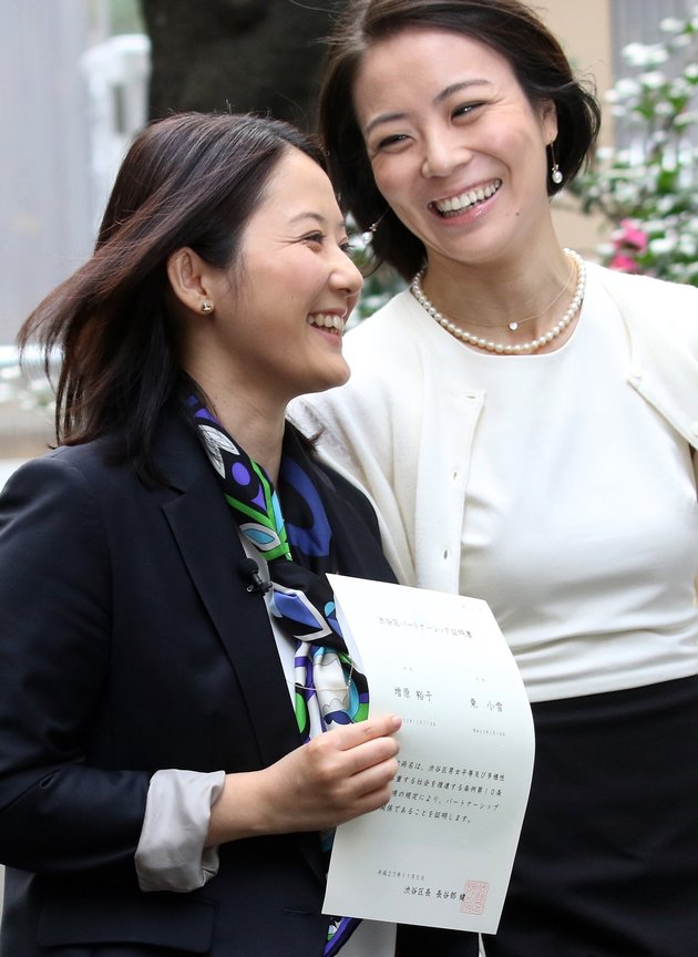 Japanese lesbian couple Hiroko Masuhara (L) and Koyuki Higashi smile as they receive a certification paper of "partnership" at the Shibuya ward office in Tokyo on November 5, 2015. While the certificates are not legally binding, the district hoped they would encourage hospitals and landlords to ensure same-sex couples receive similar treatment to married people. AFP PHOTO / Yoshikazu TSUNO        (Photo credit should read YOSHIKAZU TSUNO/AFP/Getty Images)