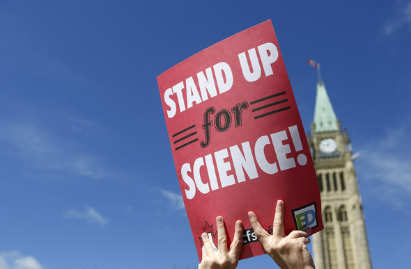 A protester holds a sign during a 'Stand Up for Science' demonstration calling on the federal government to support and fund scientific research, on Parliament Hill in Ottawa September 16, 2013.       REUTERS/Chris Wattie       (CANADA - Tags: CIVIL UNREST POLITICS SCIENCE TECHNOLOGY BUSINESS) - RTX13NTB