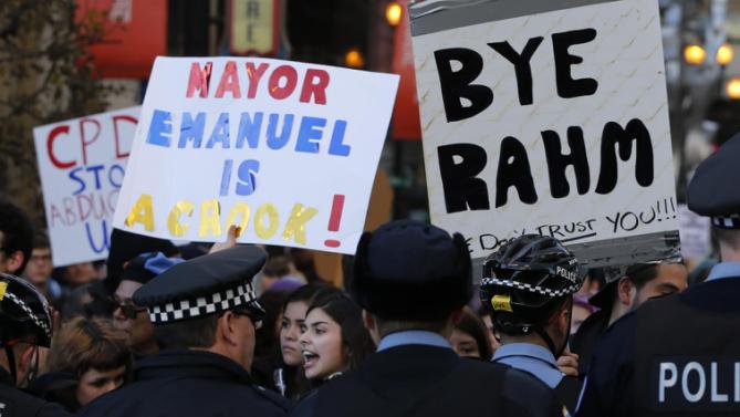 Protesters engage Chicago police officers during a march calling for Chicago Mayor Rahm Emanuel and Cook County State's Attorney Anita Alvarez to resign  in the wake of a police scandal, Wednesday, Dec. 9, 2015, in Chicago. (AP Photo/Charles Rex Arbogast)