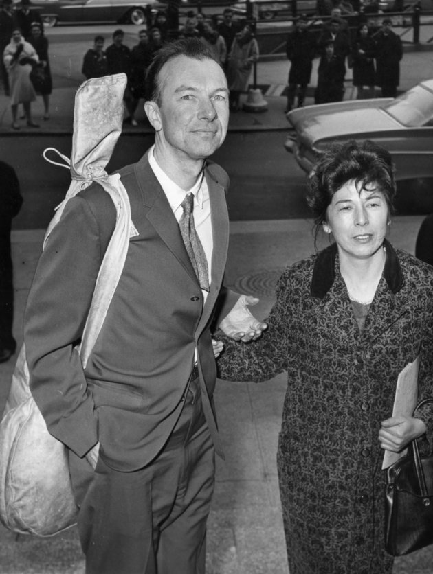 FILE - In this April 4, 1961, file photo, Pete Seeger, with a banjo slung over his shoulder, is accompanied by his wife, Toshi, as he arrives at the federal court in New York for sentencing on a conviction for contempt of Congress. The Federal Bureau of Investigation released more than 1,700 pages of documents it collected on the folk singer. (AP Photo)