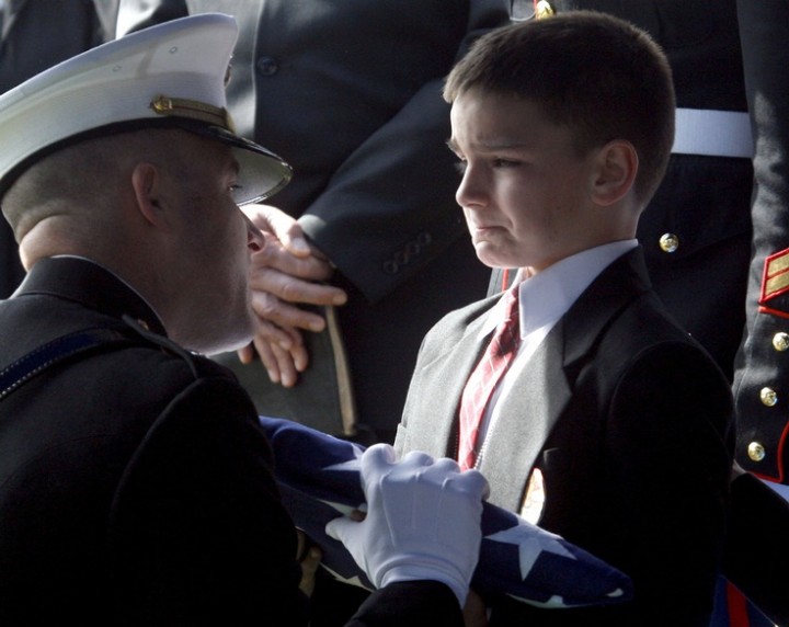 Christian Golczynski receives the flag off his fathers' coffin from Lt. Col. Ric Thompson during the graveside service at Wheeler Cemetary. Golczynski's father, Marcus, was killed by enemy guns in Iraq last week. (Aaron Thompson / DNJ)