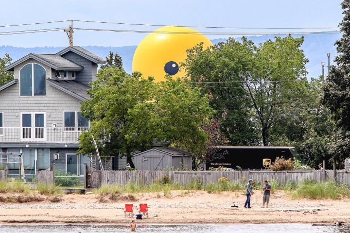 t081816 --- Clint Austin --- austinTALLSHIPS0819c17 --- Mama duck looms over unsuspecting beach goers at Park Point during the Tall Ships Duluth Parade of Sail Thursday afternoon. Mama duck is a 61-foot tall, 12-ton inflatable rubber duck.  (Clint Austin / caustin@duluthnews.com)