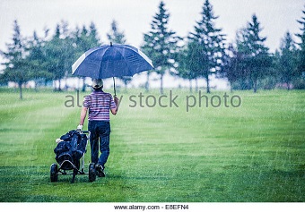 golfer-on-a-rainy-day-leaving-the-golf-course-the-game-is-annulled-e8efn4